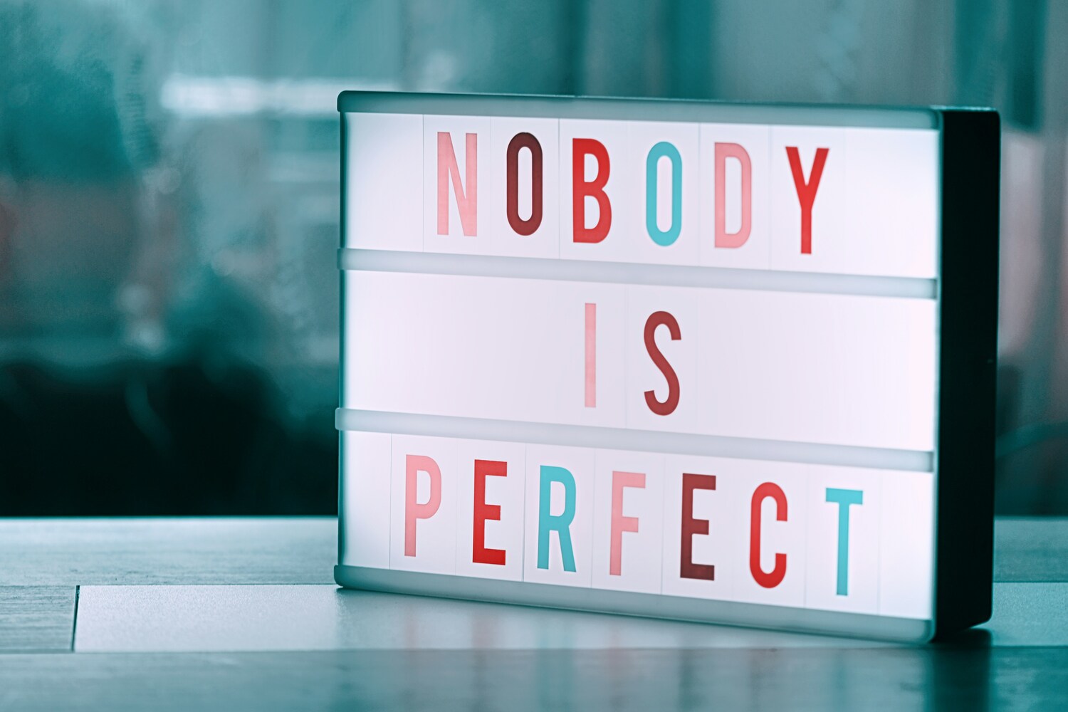 Light board with the words “NOBODY IS PERFECT”.