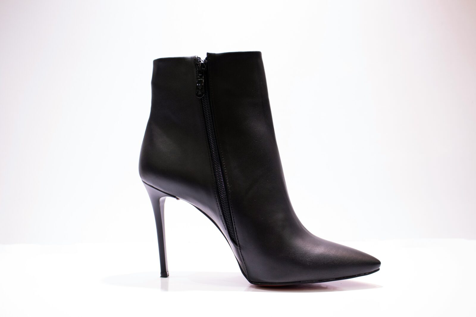 A black, stiletto-heeled boot on a white background.