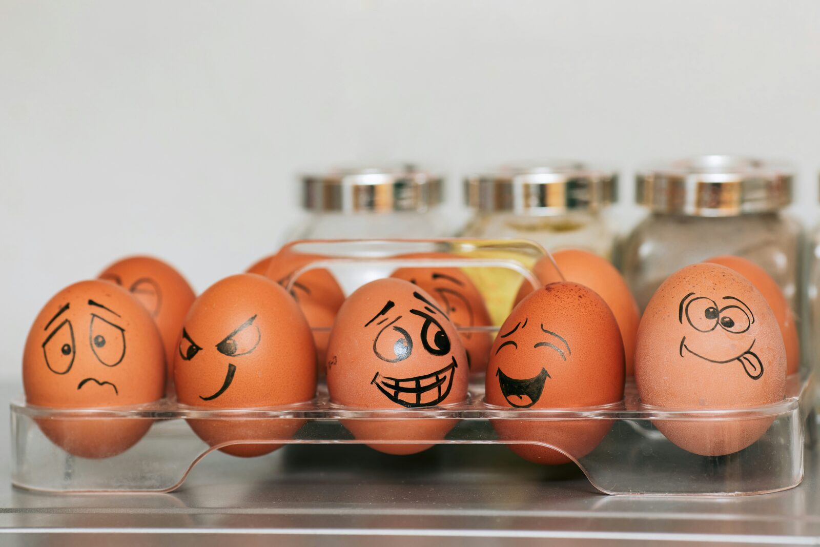 Feel your feelings. Ten eggs sit in a plastic tray. They have faces drawn on them that show different emotions.