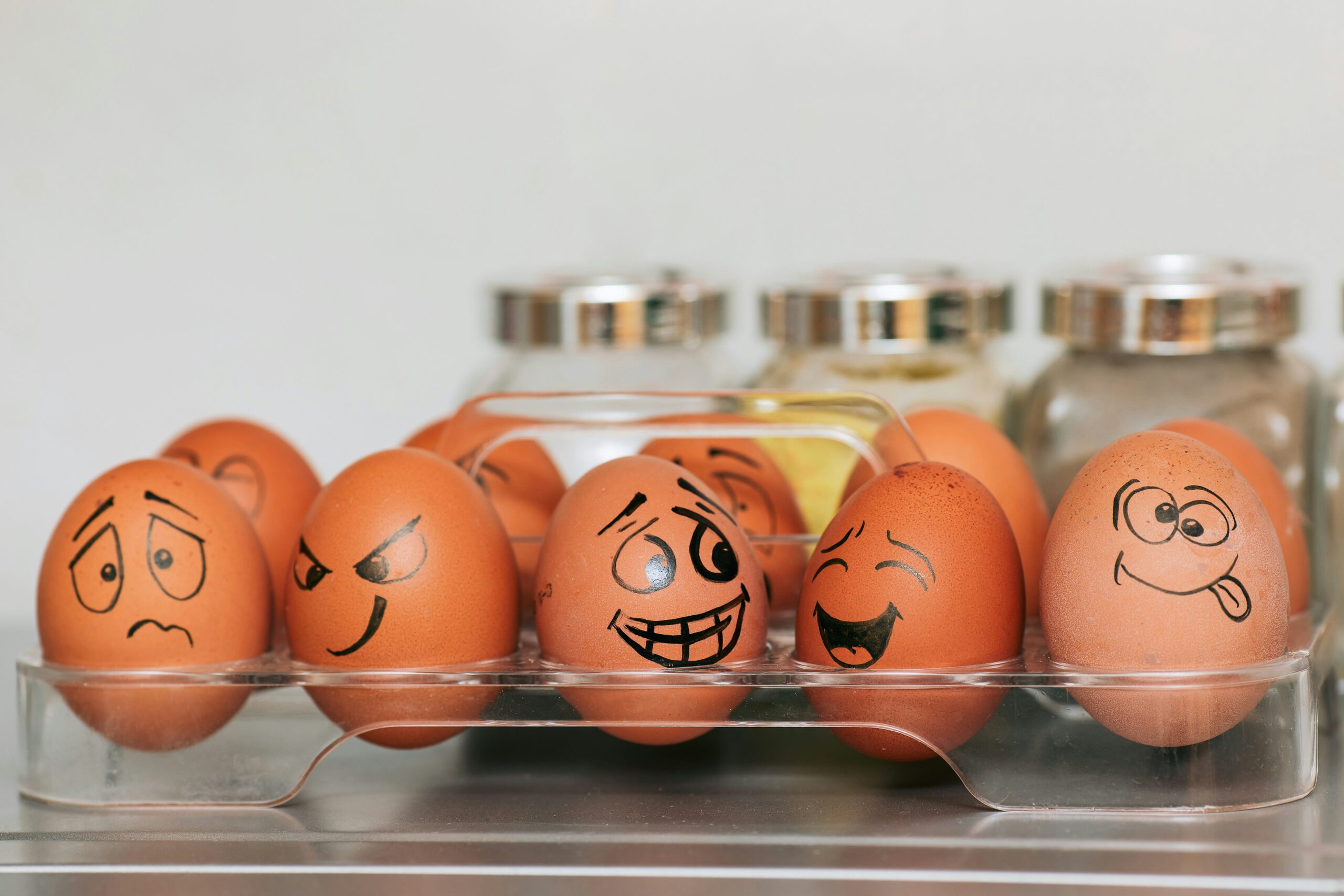 Feel your feelings. Ten eggs sit in a plastic tray. They have faces drawn on them that show different emotions.